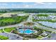 Aerial view of community pool, lush landscaping, and pond in new residential development at 4607 Dusky Dawn Ln, Palmetto, FL 34221
