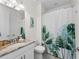 Well-lit bathroom featuring a granite vanity, toilet, and shower with decorative shower curtain creating a functional space at 4611 Los Robles Ct, Palmetto, FL 34221