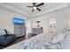 This primary bedroom has a patterned bedspread, dresser with a TV, and a bathroom doorway at 4611 Los Robles Ct, Palmetto, FL 34221