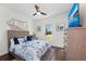 A bedroom includes a ceiling fan, dresser with a TV, and a window with natural light at 4611 Los Robles Ct, Palmetto, FL 34221