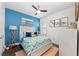 Bright bedroom features a blue accent wall, comfortable bed, and stylish decor creating a cozy and inviting atmosphere at 4611 Los Robles Ct, Palmetto, FL 34221