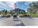 Beautiful community clubhouse entrance with well-maintained landscaping, brick accents, and welcoming flags at 4611 Los Robles Ct, Palmetto, FL 34221