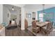 Elegant dining room with wood floors, wicker chairs and light fixture overlooking the kitchen and entryway at 4611 Los Robles Ct, Palmetto, FL 34221