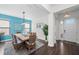 Bright dining room featuring a wooden table with wicker chairs, blue accents, and stylish lighting at 4611 Los Robles Ct, Palmetto, FL 34221