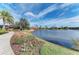 Scenic lake view featuring a stone bridge and lush landscaping, creating a serene and inviting outdoor space at 4611 Los Robles Ct, Palmetto, FL 34221