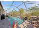 Refreshing screened-in pool area with seating, an umbrella, and a tranquil waterfall feature at 4611 Los Robles Ct, Palmetto, FL 34221