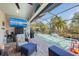 Relaxing screened-in pool area with outdoor seating, TV, and a built-in waterfall feature at 4611 Los Robles Ct, Palmetto, FL 34221