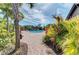 Community pool area with lush greenery, brick pathway and palm trees creating a serene and relaxing atmosphere at 4611 Los Robles Ct, Palmetto, FL 34221