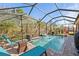 Serene screened-in pool area with ample seating, an umbrella, and a relaxing waterfall feature at 4611 Los Robles Ct, Palmetto, FL 34221