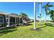 View of the backyard with screened-in lanai, green lawn, and palm trees offering privacy and shade at 4629 Samoset Dr, Sarasota, FL 34241