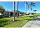 Backyard view features a screened-in lanai, manicured lawn, and mature palm trees lining the property at 4629 Samoset Dr, Sarasota, FL 34241