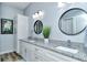 Bathroom with double vanity, framed mirrors, granite countertops, and decorative art at 4629 Samoset Dr, Sarasota, FL 34241