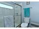 Bright bathroom featuring a shower with glass doors, toilet, and decorative accents at 4629 Samoset Dr, Sarasota, FL 34241