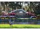 Elegant community entrance with stone signage, colorful landscaping, and two great blue herons at 4629 Samoset Dr, Sarasota, FL 34241