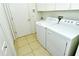 Practical laundry room with white appliances, tiled flooring, and ample storage at 4629 Samoset Dr, Sarasota, FL 34241