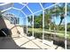 Screened-in patio area showcasing a grill, lounge chair, and a serene landscape view at 4629 Samoset Dr, Sarasota, FL 34241