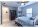 Well-lit bedroom with a ceiling fan, decorative bedframe, and a classic dresser with a view into the hallway at 4747 Motta Ct, Bradenton, FL 34211