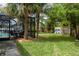 A backyard is furnished with a dining table and chicken coop on a lush green lawn at 4807 W Country Club Dr, Sarasota, FL 34243