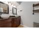 Bathroom with dual vessel sinks, dark wood cabinets, and a large, framed mirror at 4807 W Country Club Dr, Sarasota, FL 34243