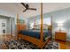 Well lit bedroom features a four-poster bed, area rug, ceiling fan, and two windows at 4807 W Country Club Dr, Sarasota, FL 34243