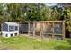 A chicken coop and enclosure are framed by lush greenery at 4807 W Country Club Dr, Sarasota, FL 34243
