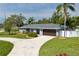 Charming single-story home featuring a landscaped front yard, and a beautiful blue exterior at 4807 W Country Club Dr, Sarasota, FL 34243