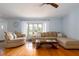 Bright living room features hardwood floors, large windows, comfortable seating, and a ceiling fan at 4807 W Country Club Dr, Sarasota, FL 34243