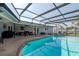 A screened in backyard pool and spa are surrounded by a stone deck at 4807 W Country Club Dr, Sarasota, FL 34243