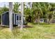 A backyard features a shed, chicken coop and is framed by palm trees at 4807 W Country Club Dr, Sarasota, FL 34243