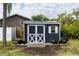 A dark shed with solar panels is in a sunny, landscaped backyard at 4807 W Country Club Dr, Sarasota, FL 34243