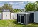 Two storage sheds are newly constructed and framed by a white fence and greenery at 4807 W Country Club Dr, Sarasota, FL 34243