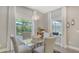 Elegant dining area with a glass table, comfortable seating, and natural light from nearby windows at 4832 Boston Common Gln, Bradenton, FL 34211