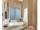 Bright bathroom showcasing a large bathtub under a window with blinds, and a separate shower at 5224 88Th E St, Bradenton, FL 34211