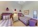 Bedroom with two twin beds featuring matching purple accents, a central nightstand, and warm, inviting lighting at 5224 88Th E St, Bradenton, FL 34211