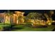 Night view of the home exterior showcasing professionally illuminated landscaping and mature trees at 5224 88Th E St, Bradenton, FL 34211