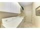 Well-equipped laundry room with washer, dryer, overhead cabinets, countertop, and neutral-toned decor at 5224 88Th E St, Bradenton, FL 34211