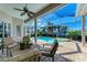 Covered patio area with comfortable seating overlooking a sparkling pool, jacuzzi, and lush tropical landscape at 5224 88Th E St, Bradenton, FL 34211