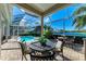Screened patio featuring an outdoor dining area with a pool and lake view beyond manicured landscaping at 5224 88Th E St, Bradenton, FL 34211