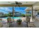 Relaxing covered patio with stylish seating, scenic views of the pool, spa, and tranquil lake at 5224 88Th E St, Bradenton, FL 34211