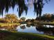 Scenic view of a pond reflecting mature trees, enhancing the serene and tranquil beauty of the community's golf course at 5224 88Th E St, Bradenton, FL 34211