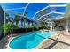 Sparkling pool and spa with a screened enclosure and lush landscaping overlooking a serene lake at 5224 88Th E St, Bradenton, FL 34211