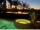 Illuminated spa at twilight, featuring a gentle waterfall and serene lake view at 5224 88Th E St, Bradenton, FL 34211