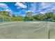 Exterior view of a tennis court with green turf and a covered seating area at 5224 88Th E St, Bradenton, FL 34211