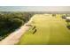 Aerial view of golf course with lush greenery, mature trees, sand traps and two golf carts at 5685 Palmer Cir # 202, Bradenton, FL 34211