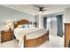 Bright bedroom with a wooden bed frame, soft white bedding, and a window providing natural light at 5685 Palmer Cir # 202, Bradenton, FL 34211