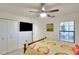 Clean bedroom with a mounted TV, standard closet, and a sunny window view at 5685 Palmer Cir # 202, Bradenton, FL 34211