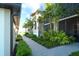 Attractive condo exterior featuring a brick pathway, complemented by green shrubs and vibrant tropical landscaping at 5685 Palmer Cir # 202, Bradenton, FL 34211