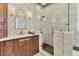 Spacious primary bathroom with wood cabinets, white countertops, and a frameless glass shower with elegant fixtures at 6600 Horned Owl Pl, Sarasota, FL 34241