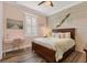 Bright bedroom featuring shiplap accent wall, wood floors, and a desk near the window at 6600 Horned Owl Pl, Sarasota, FL 34241