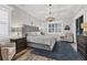 Elegant bedroom with a coffered ceiling, tufted headboard, and stylish chandelier at 6600 Horned Owl Pl, Sarasota, FL 34241